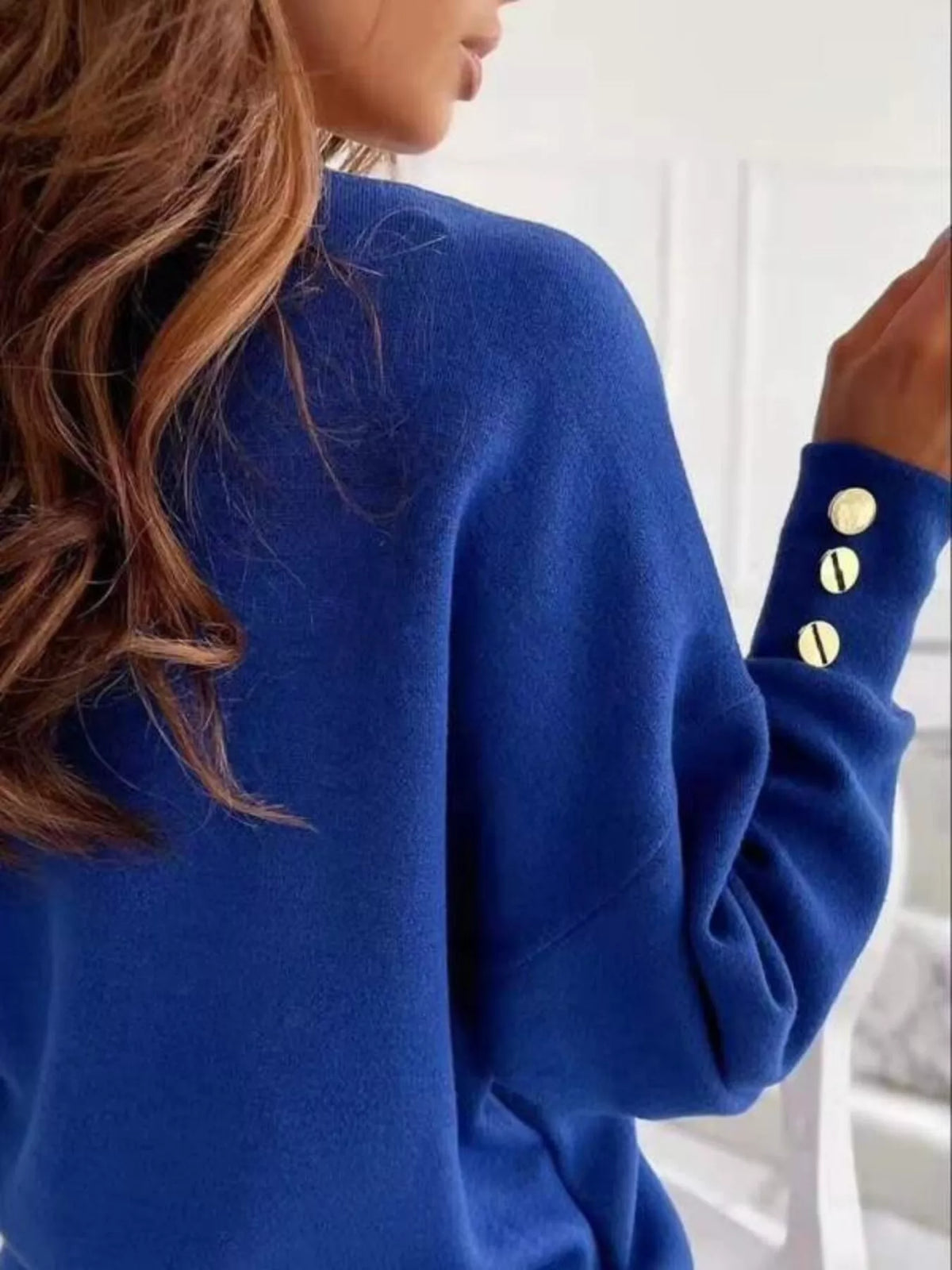 Women's V-neck button cuff blouse by Trendsi, featuring a stylish V-neck neckline, button cuffs, and lightweight fabric.