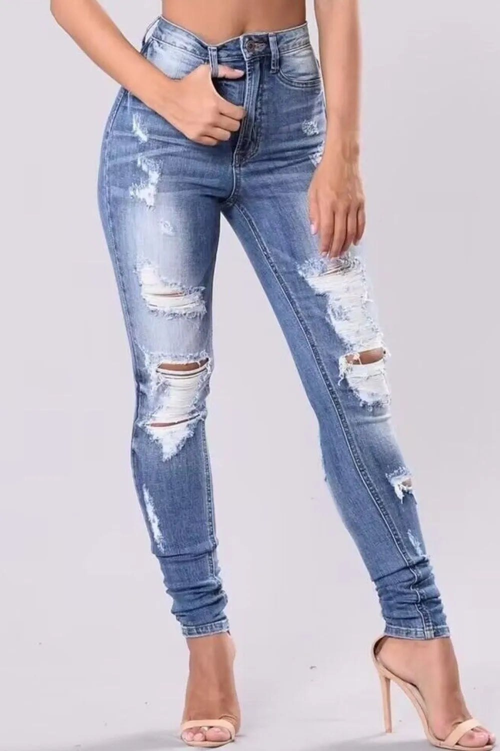 Plus size distressed skinny denim jeans by Trendsi, showcasing full-length fit with ripped details and a classic blue wash.