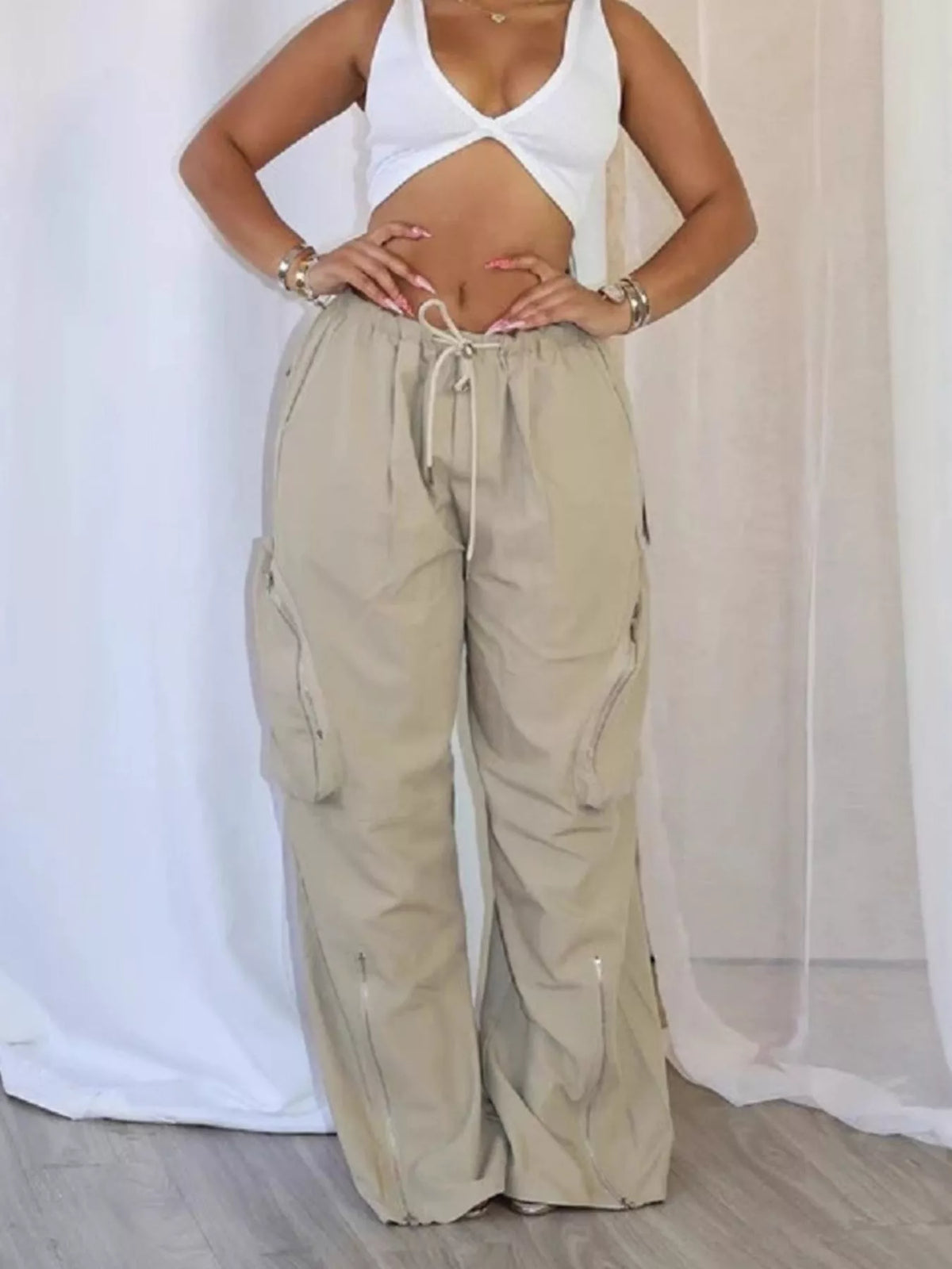 Trendsi drawstring cargo pants with zipper accents, featuring multiple pockets and a relaxed fit, styled for casual wear.