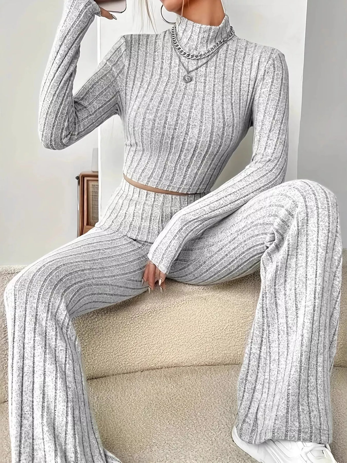 Ribbed turtleneck crop top and flare pants sweater set by Trendsi, featuring a cozy knit design in a stylish matching ensemble.