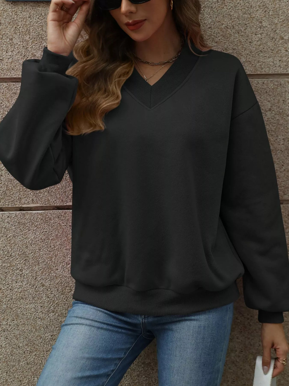 V-neck solid color casual sweatshirt by Trendsi, featuring a relaxed fit and soft fabric, displayed in a neutral color.