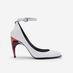 White pointed-toe stilettos with ankle strap, silver buckle, and a red and black sculptural colorblock heel.