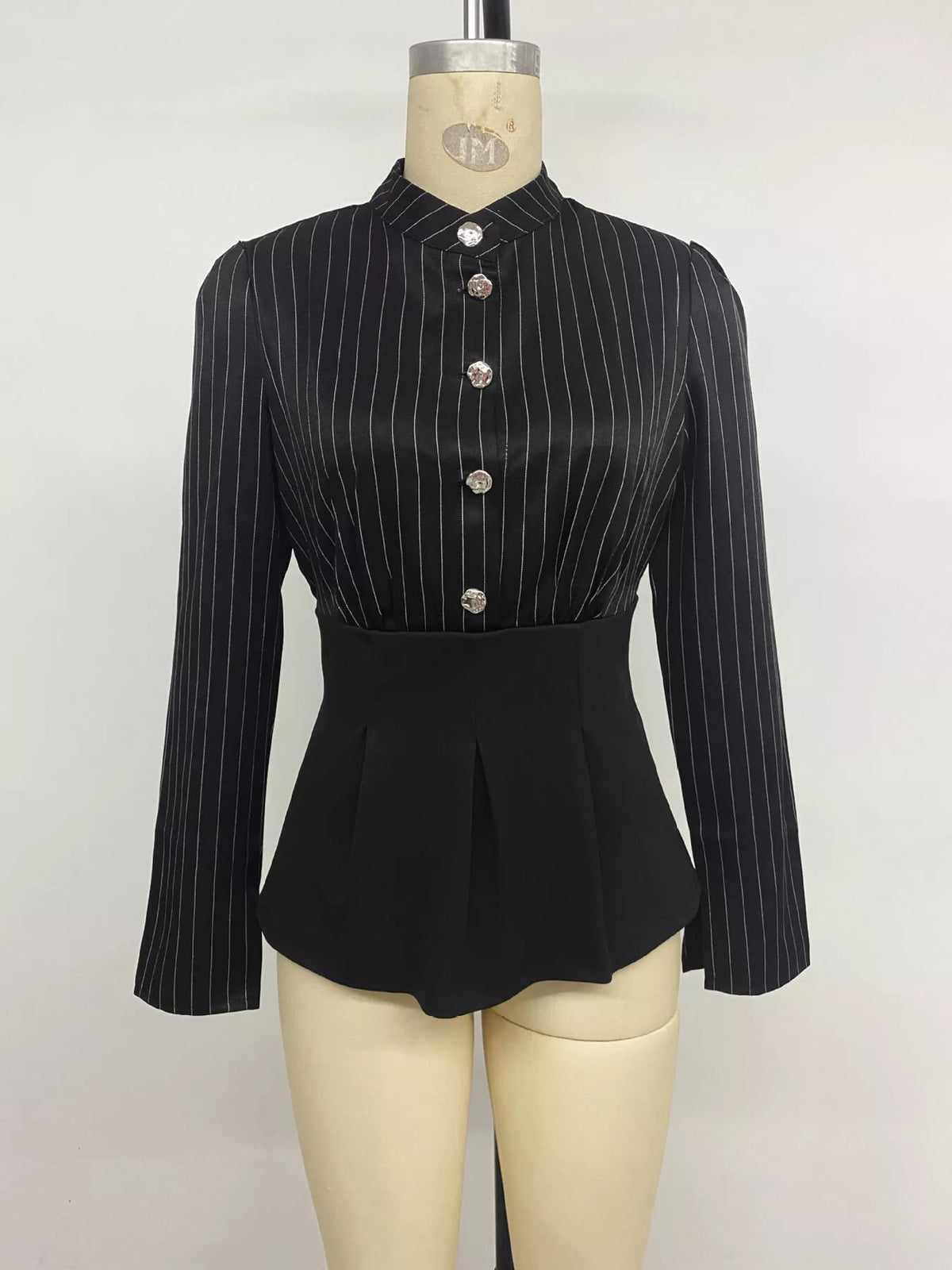 Striped long sleeve peplum blouse for women by Trendsi, featuring a fitted design with contrasting horizontal stripes.