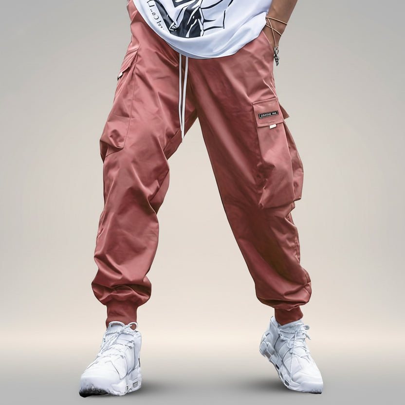 Men's streetwear cargo pants with multiple pockets and drawstring waist by FitiqueFit, shown in a casual urban outfit.