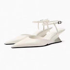Elegant white pointed-toe wedge sandals with slim buckled ankle straps and unique sculpted metallic silver wedge heels.