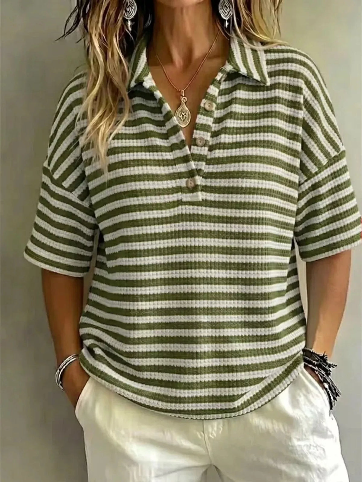 Plus size contrast striped knit polo shirt for women, featuring a classic polo collar and bold striped pattern, from Trendsi.