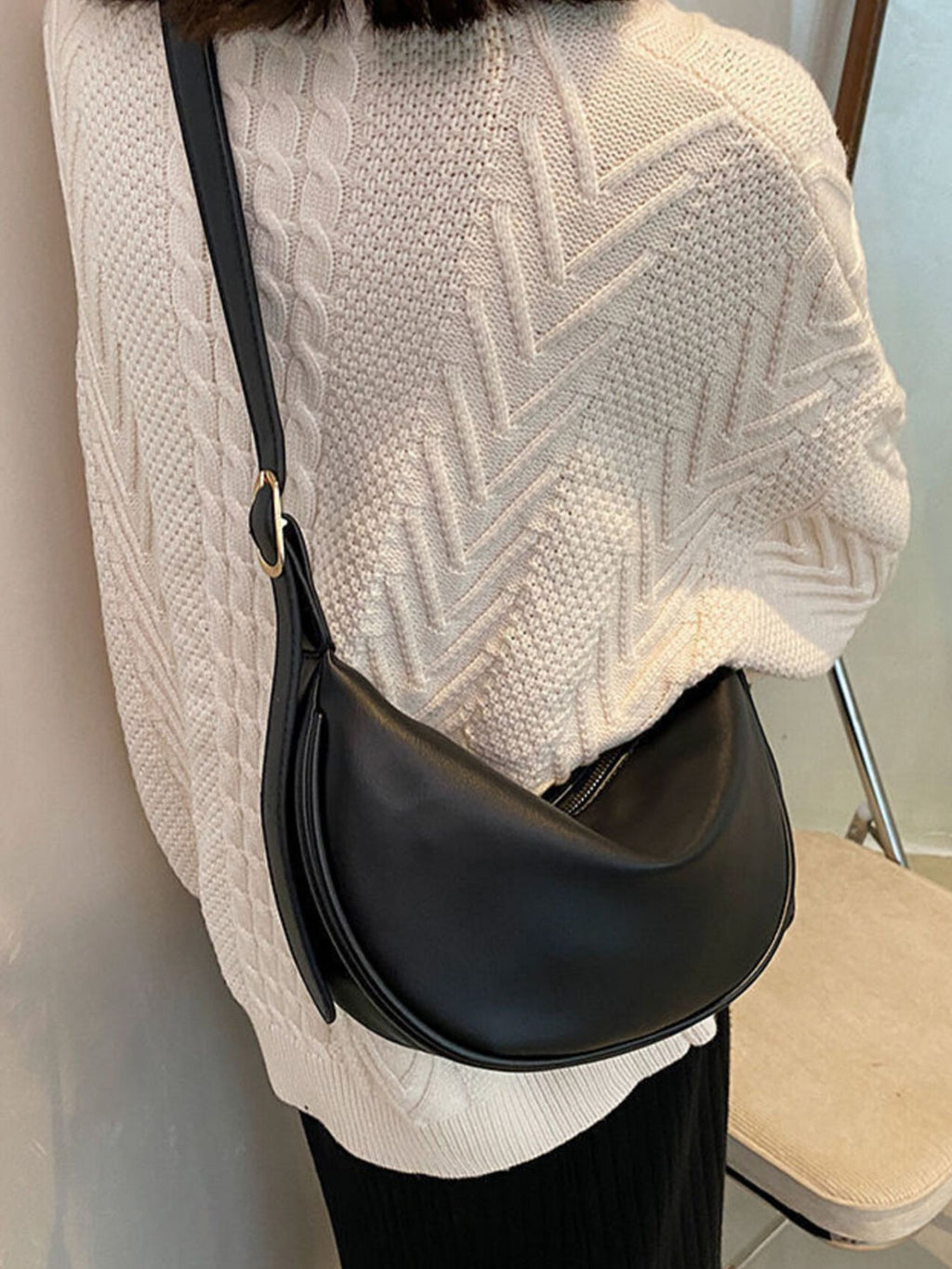 Minimalist crescent-shaped crossbody bag made of smooth PU leather, featuring a sleek shoulder purse design.