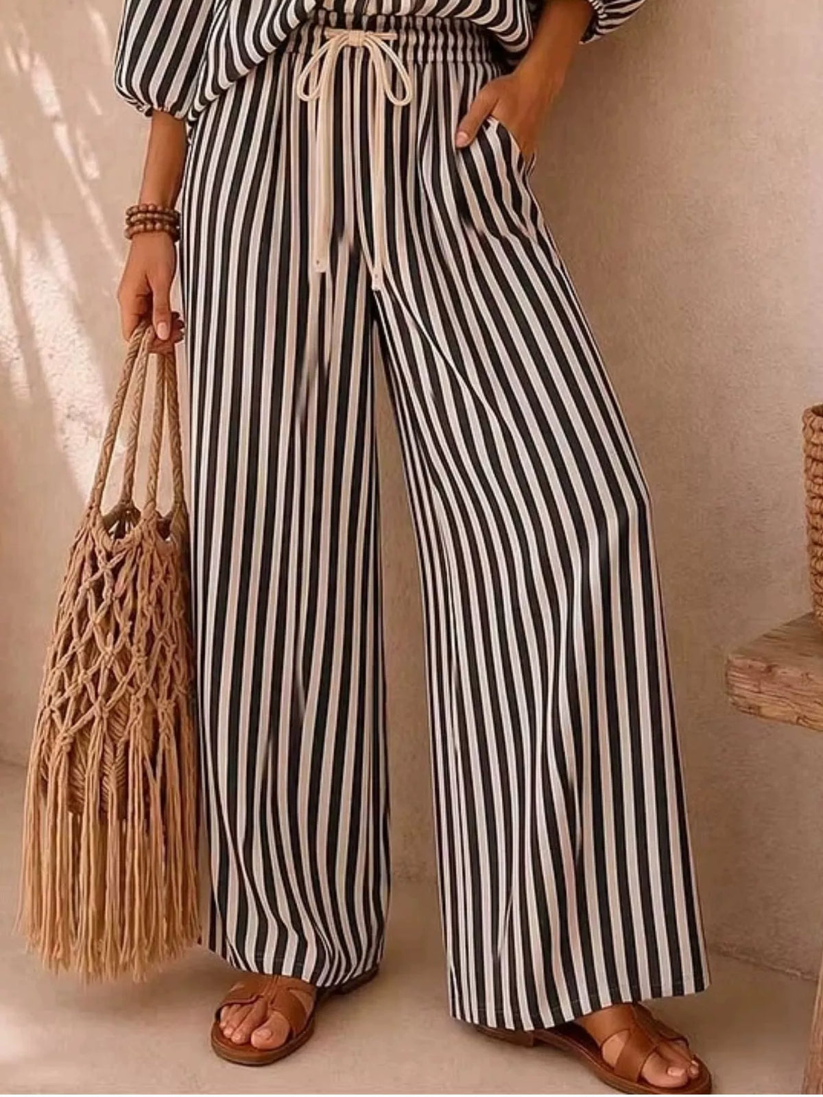 Plus size striped puff sleeve shirt and wide-leg drawstring pants set by Trendsi, featuring bold stripes and relaxed fit.