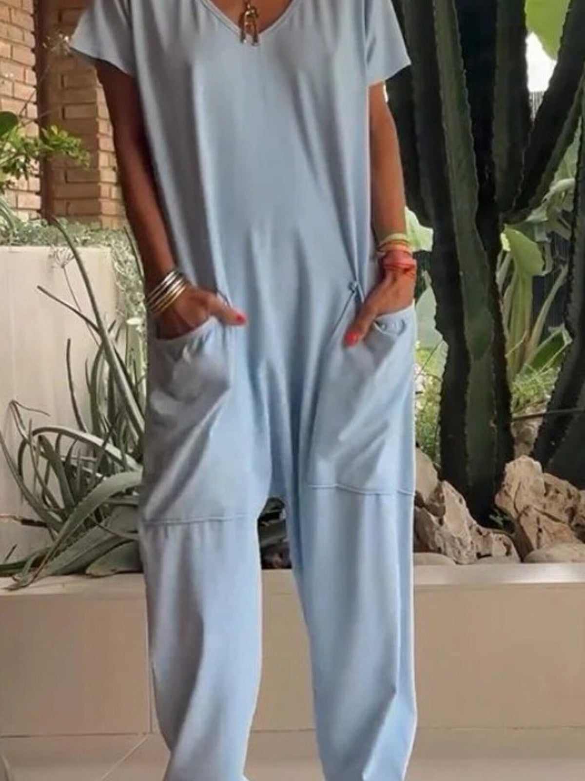 Plus size full-length V-neck jumpsuit by Trendsi featuring short sleeves and wide-leg fit, casual and comfortable for everyday wear.