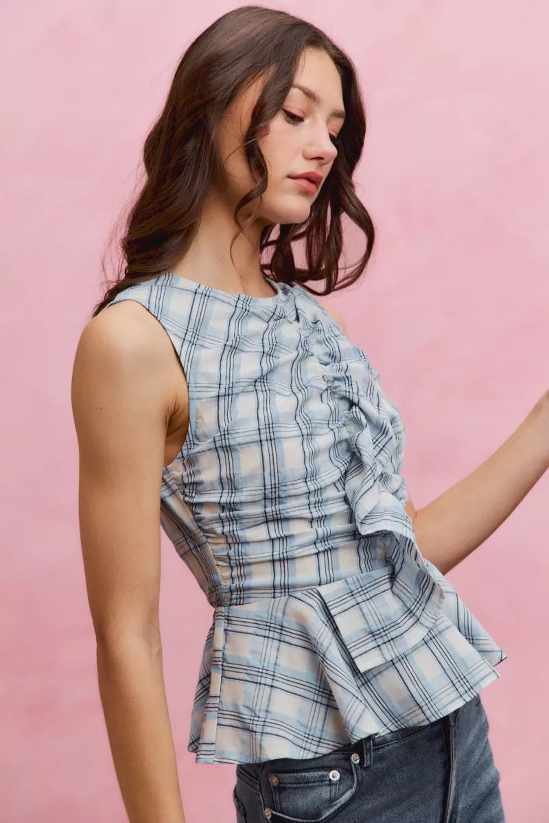 Plaid sleeveless ruffle peplum top by Plush Fashion Hub, featuring a stylish plaid pattern and feminine ruffle details.