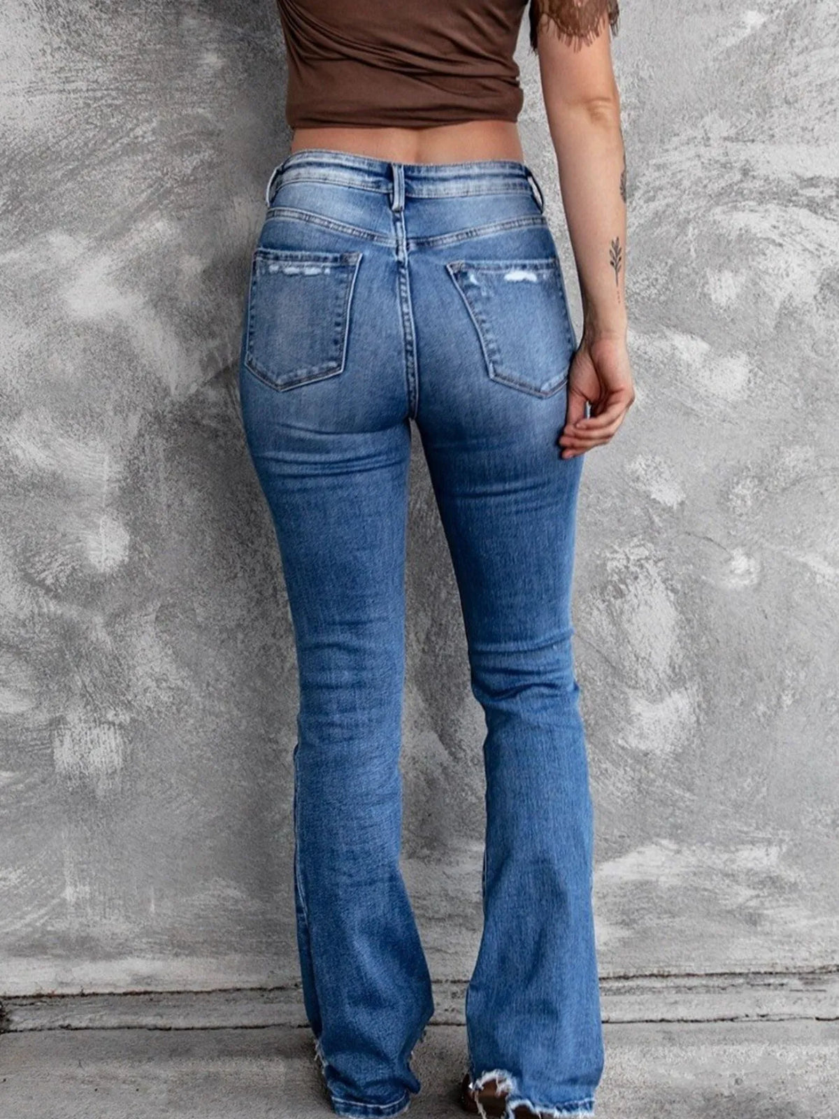 Distressed flare denim jeans from Plush Fashion Hub featuring ripped details and a high-waist fit, styled on a model.