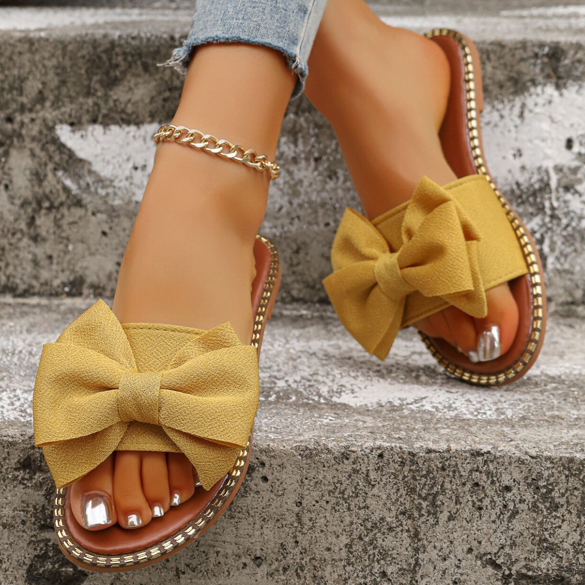 Plush Fashion Hub bowknot embellished flat sandals with open toes and adjustable ankle straps on a neutral background.