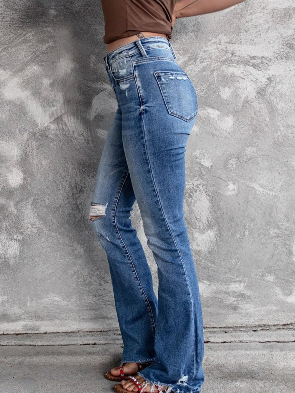 Distressed flare denim jeans from Plush Fashion Hub featuring rips and a high-waisted fit, styled on a model.