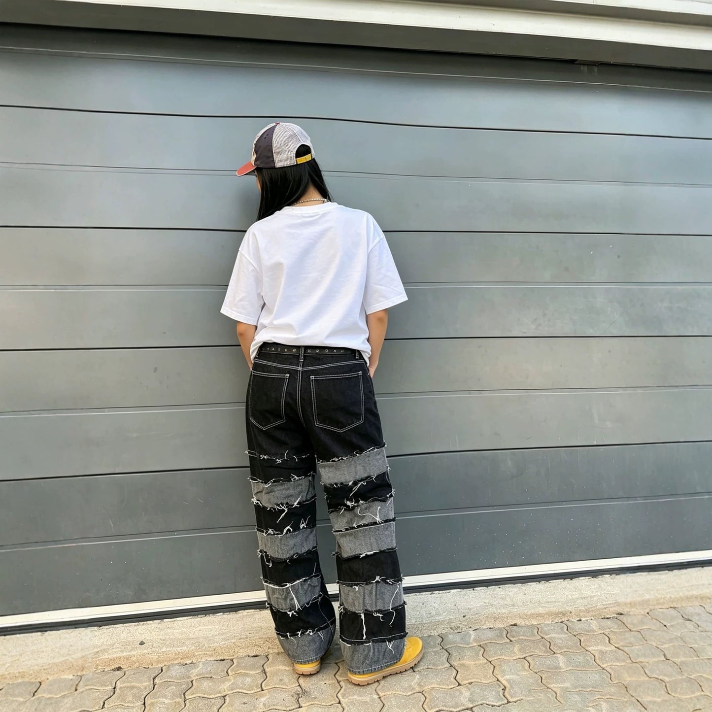 Women's deconstructed black and gray patchwork denim jeans with straight fit, branded eprolo, showcasing stylish distressed detailing.