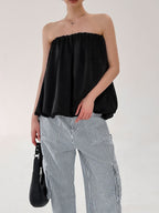 Women's strapless bubble hem tube top by Trendsi, featuring a sleek minimalist crop top design with a trendy, modern look.