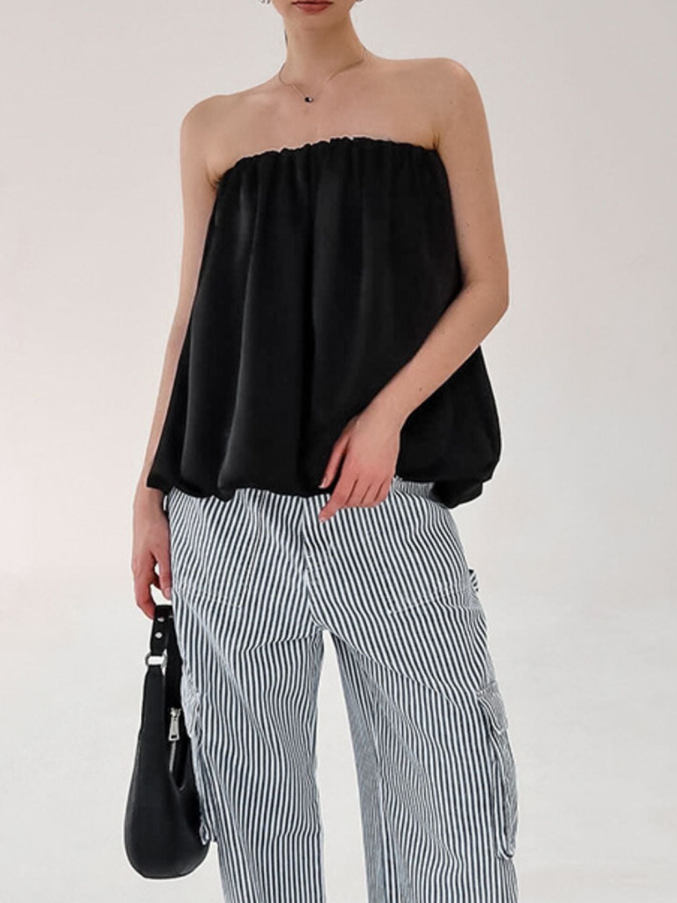 Women's strapless bubble hem tube top by Trendsi, featuring a sleek minimalist crop top design with a trendy, modern look.