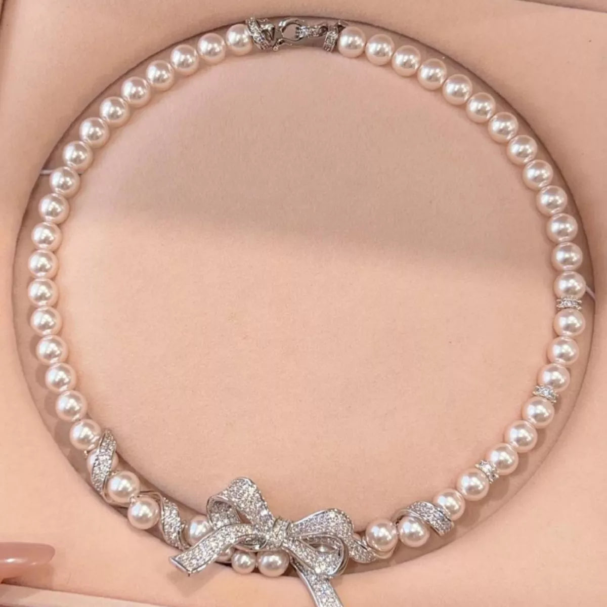 Elegant pearl necklace with a bow pendant from Plush Fashion Hub, featuring a string of lustrous pearls and a delicate bow charm.