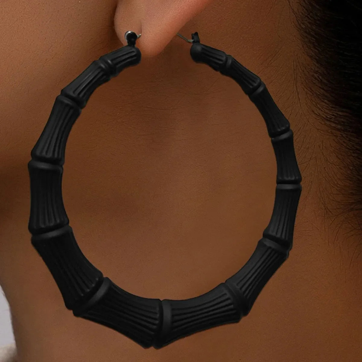Stainless steel textured hoop earrings from Plush Fashion Hub, showcasing their shiny, intricate design and circular shape.