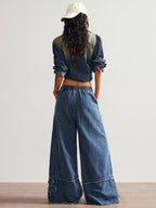Wide leg jeans by Shopimist with floral appliques, featuring a relaxed fit and decorative floral embroidery details.