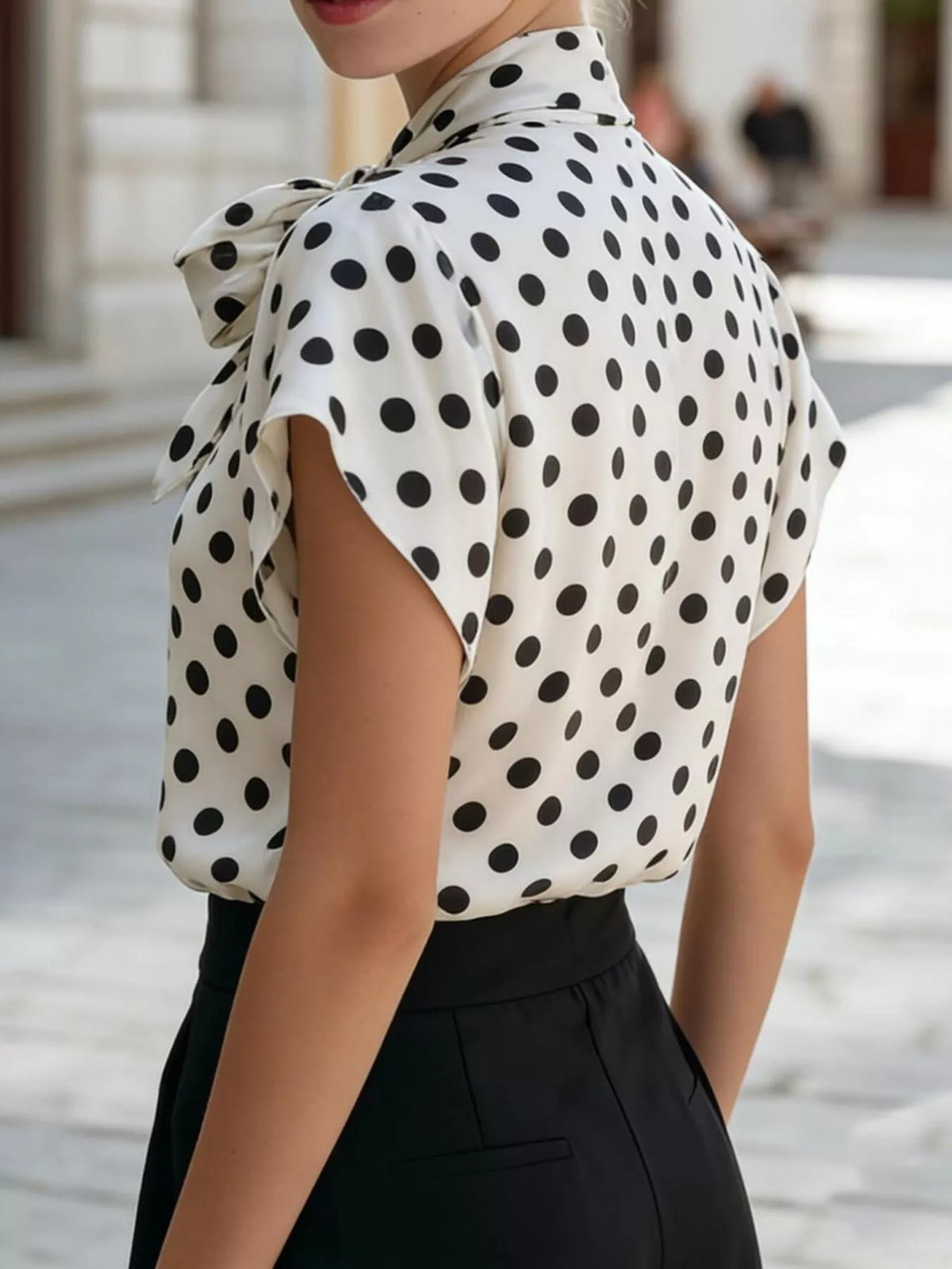 Women's Polka Dot Bow Tie Blouse by Trendsi featuring a stylish bow and polka dot pattern, perfect for casual or office wear.
