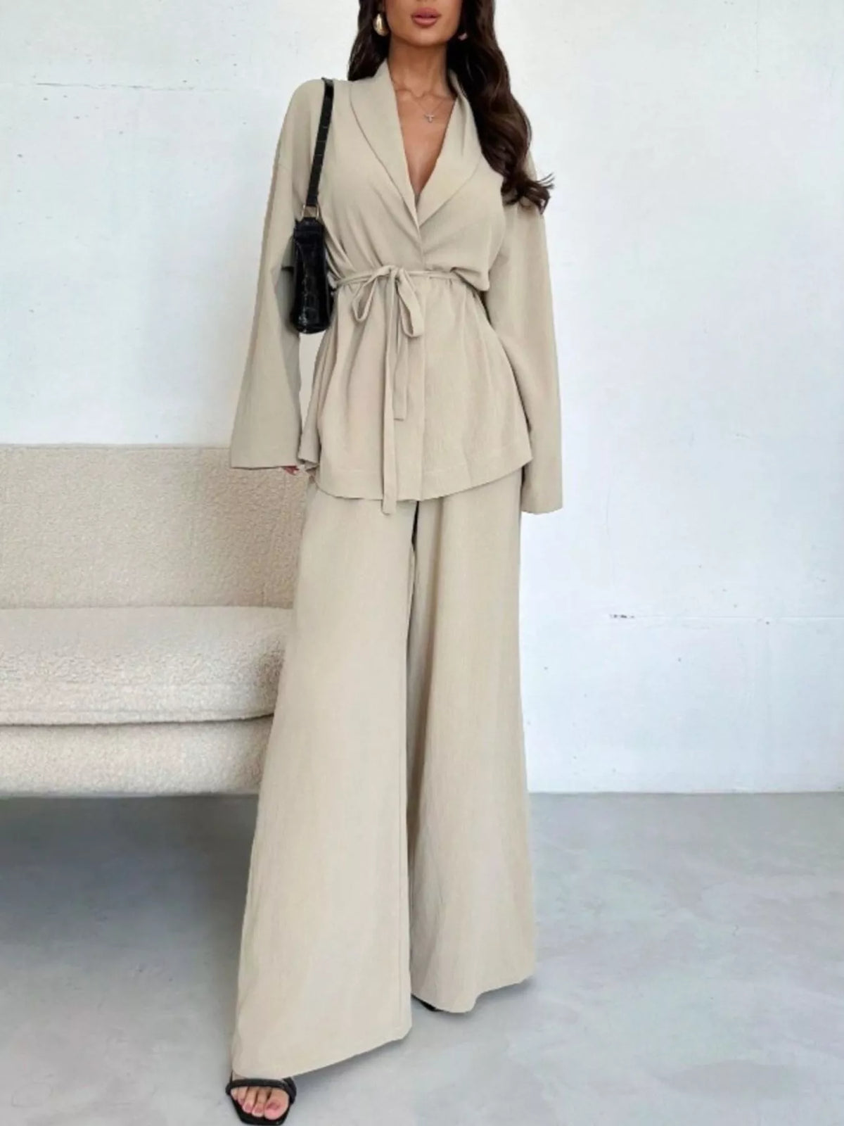 Textured tie waist top and wide-leg pants set for women by Trendsi, featuring a stylish, coordinated outfit with a comfortable fit.