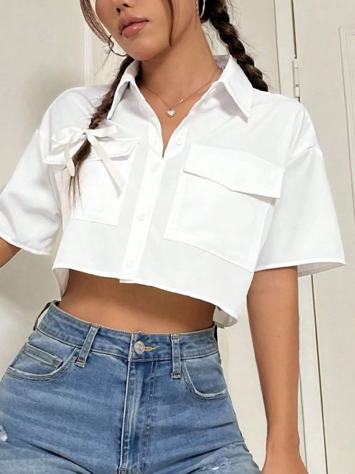 Short sleeve crop shirt with chest pockets by Trendsi, featuring a stylish and casual top design perfect for warm weather.