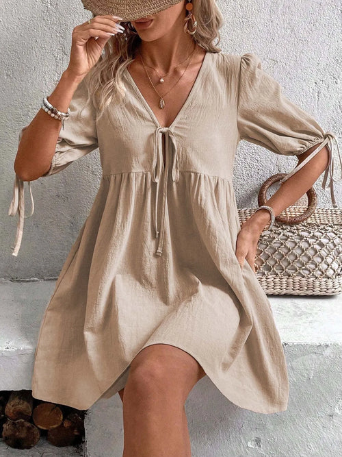 Cotton V-neck tie-front mini dress with puff sleeves, stylish and lightweight, from Trendsi, perfect for casual or summer wear.
