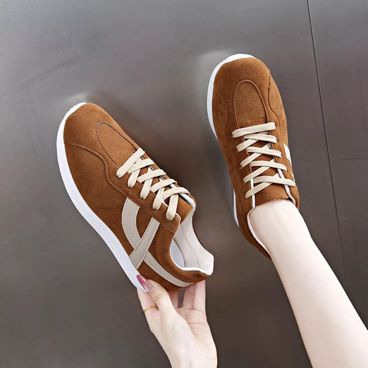 Women’s round toe lace-up sneakers by Trendsi featuring stylish design and comfortable fit, shown in a natural product setting.