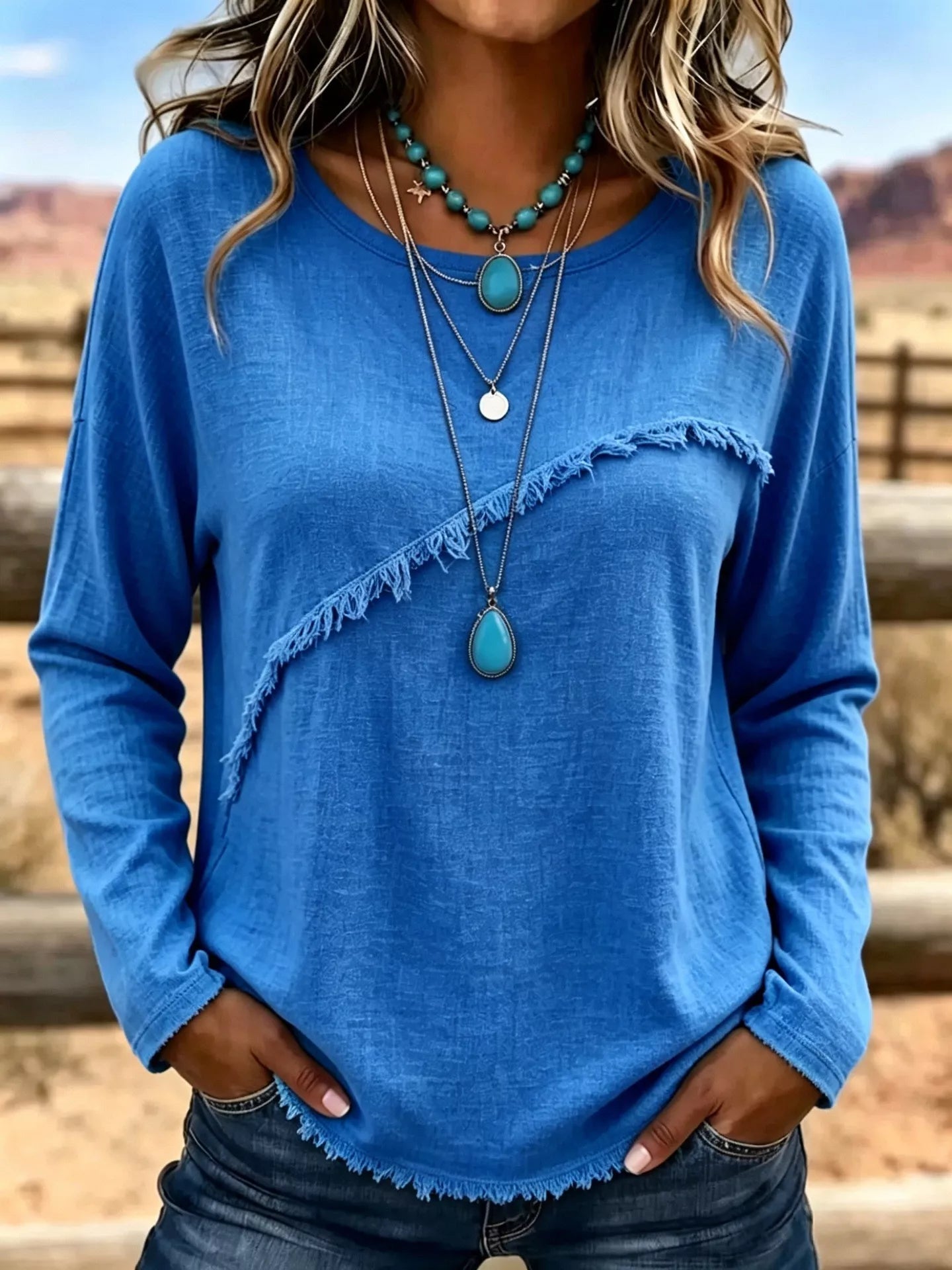 Plus size long sleeve fringe detail T-shirt by Trendsi, showing a comfortable black top with decorative fringe accents.