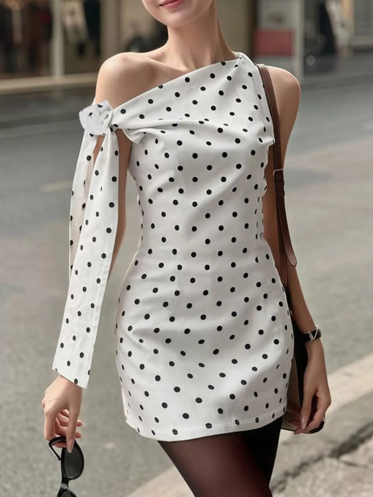 Polka dot sleeveless mini dress from Plush Fashion Hub with bow accents, featuring a fitted bodice and playful design.