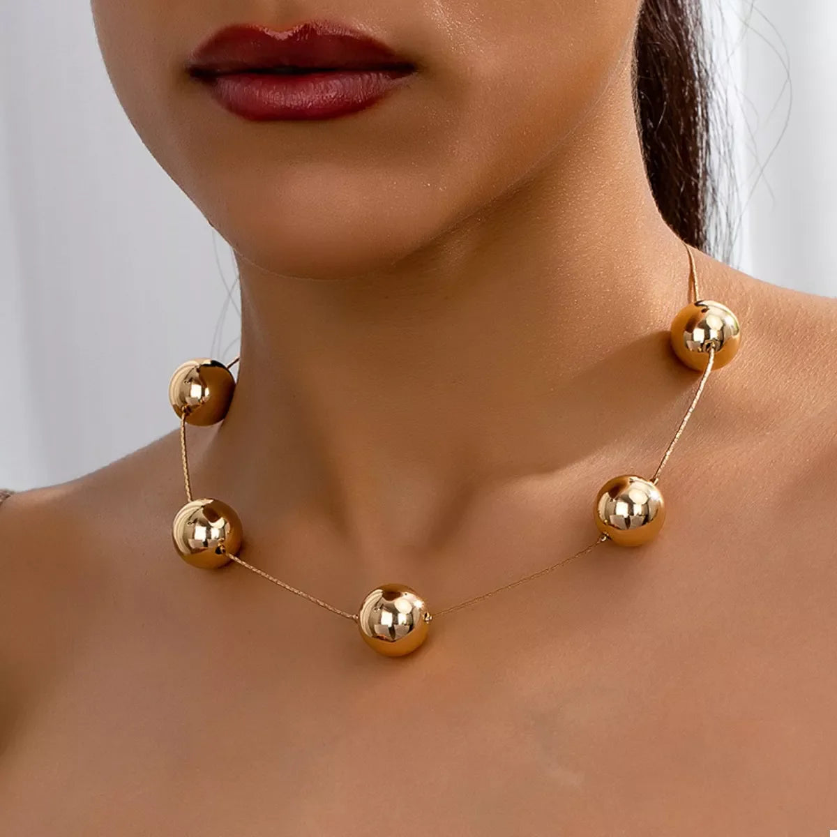 Golden sphere statement necklace by Plush Fashion Hub featuring large spherical pendants on a stylish chain.