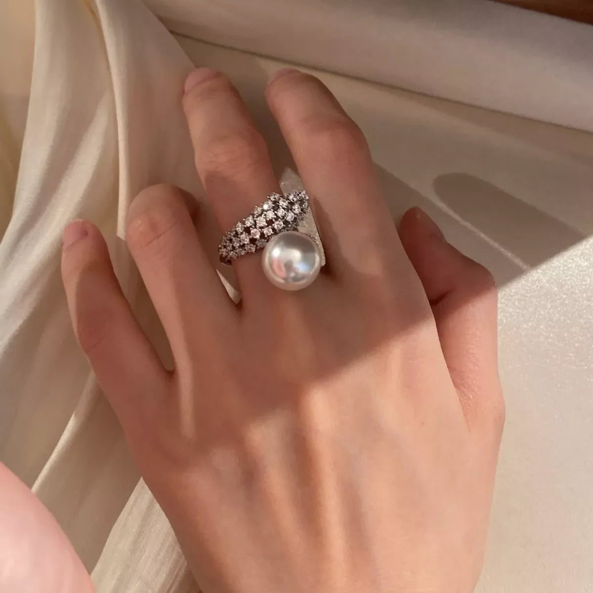 Sterling silver Pearl Bypass Ring with smooth curves and shiny finish, showcasing elegant design and lustrous pearls.