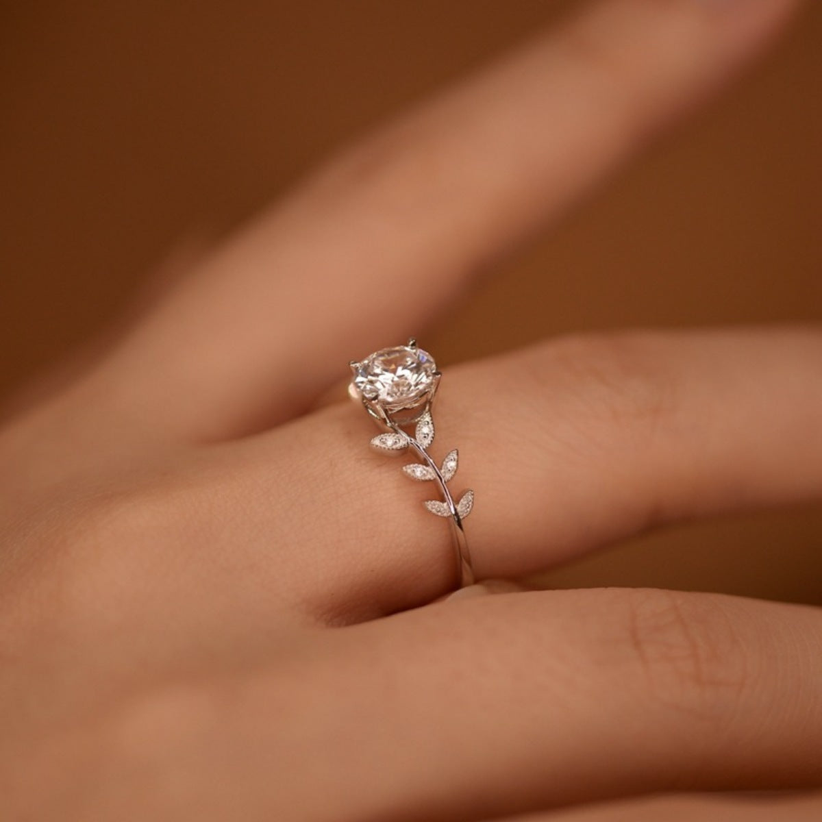 Sterling silver leaf ring with 1 carat moissanite gemstone, featuring intricate leaf design, from Plush Fashion Hub.