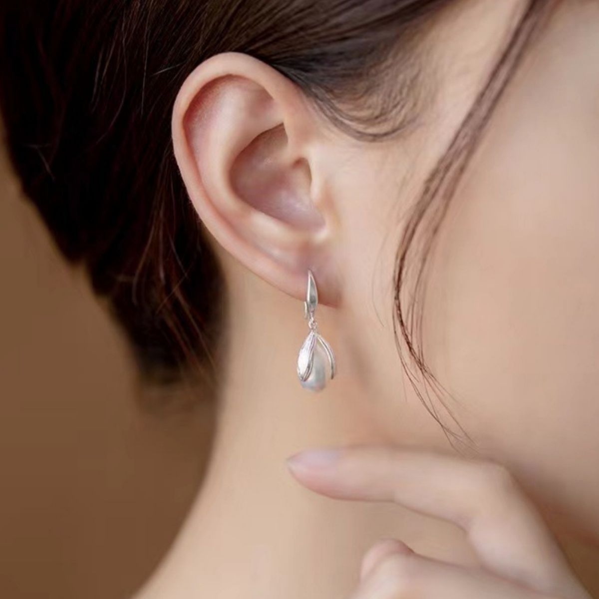 Sterling silver drop earrings with delicate design, featuring polished silver hooks and elegant dangling elements.
