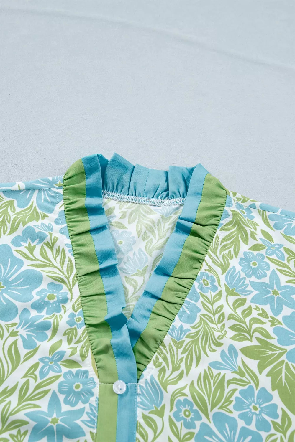 Floral print ruffle hem button-up mini dress by Trendsi, featuring a feminine design with a V-neck and short sleeves.