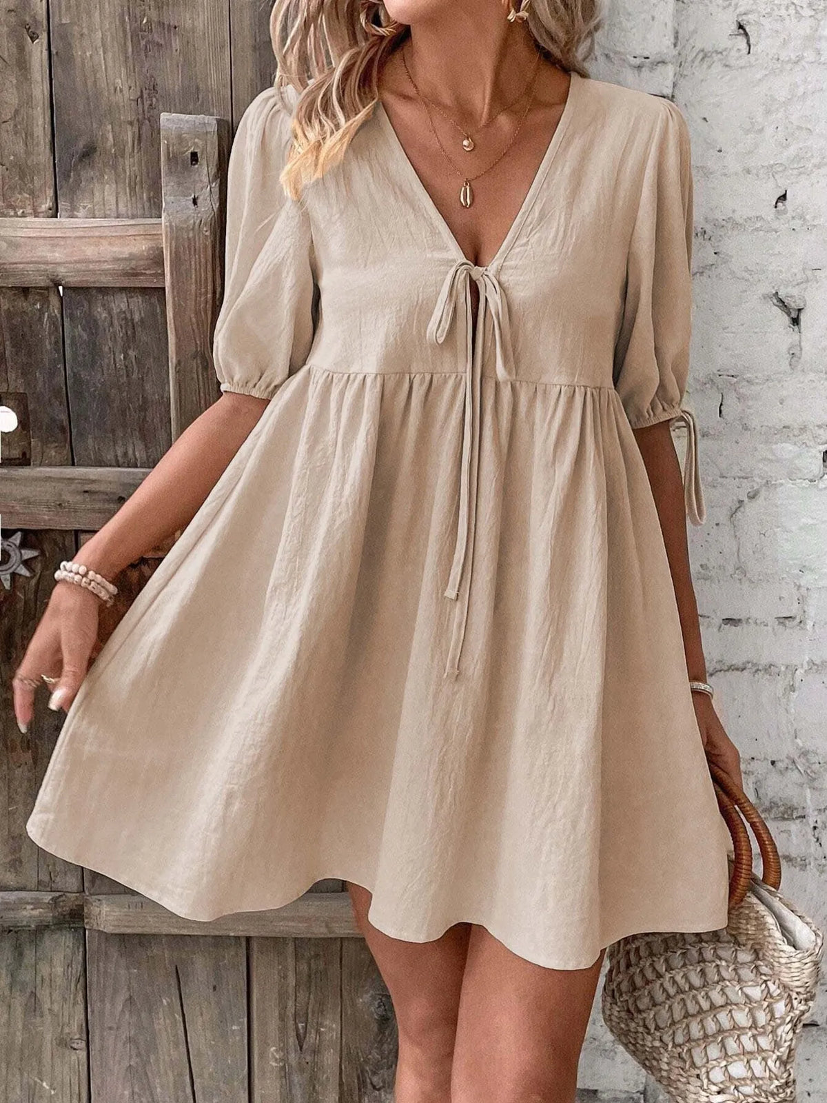 Cotton V-neck tie-front mini dress with puff sleeves by Plush Fashion Hub, shown in a stylish, casual design.