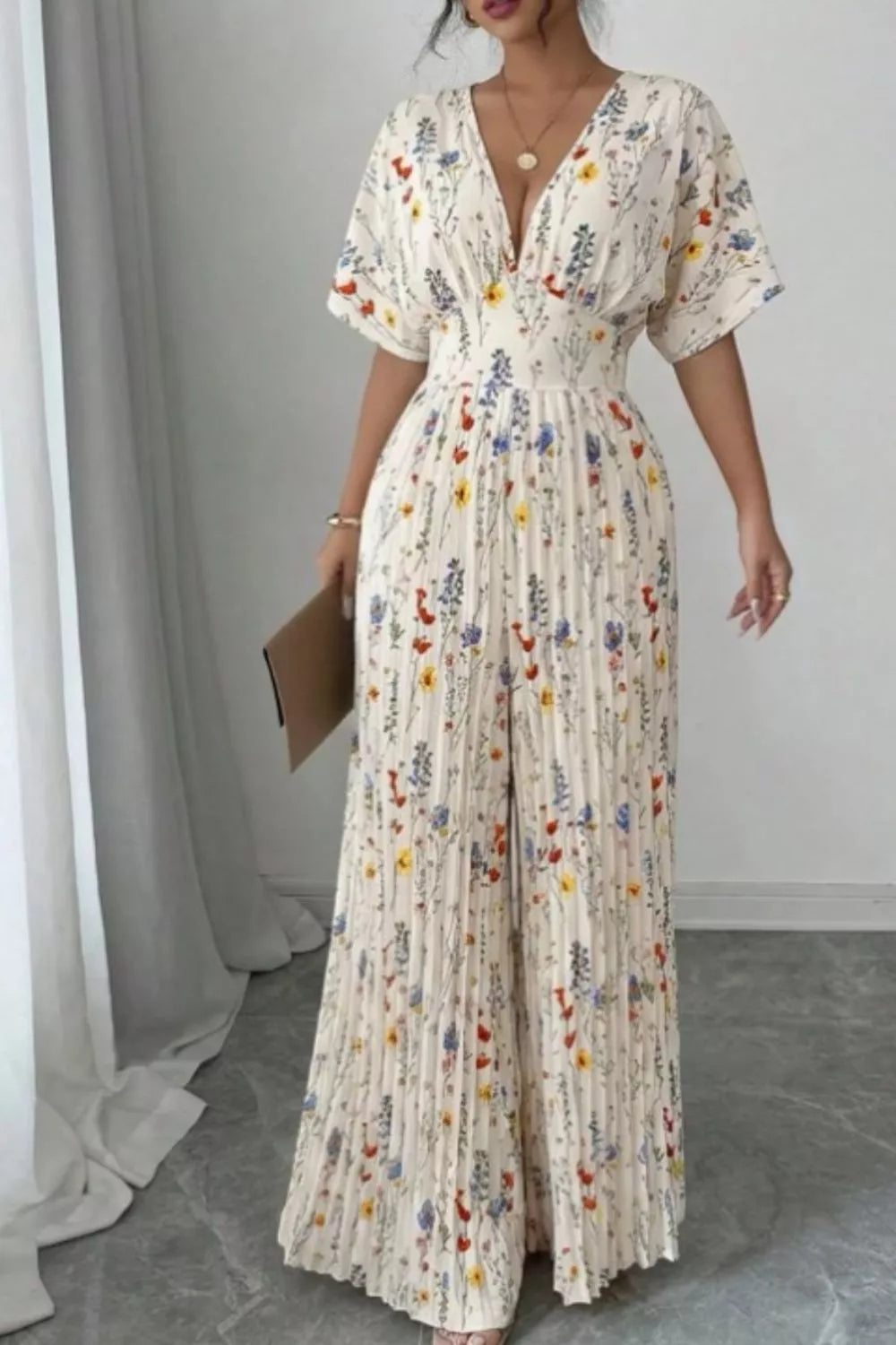 Floral print wide-leg pleated jumpsuit by Plush Fashion Hub showing flowing fabric and stylish design on a model.