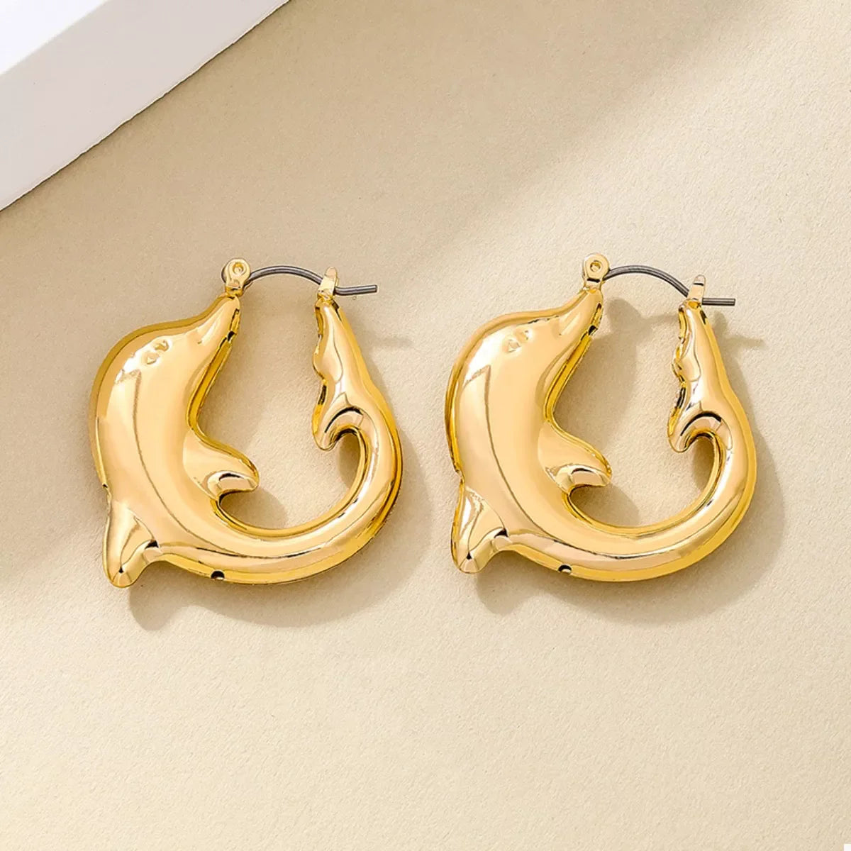 Gold-plated dolphin hoop earrings with intricate detailing, crafted by Plush Fashion Hub, perfect for stylish accessory wear.