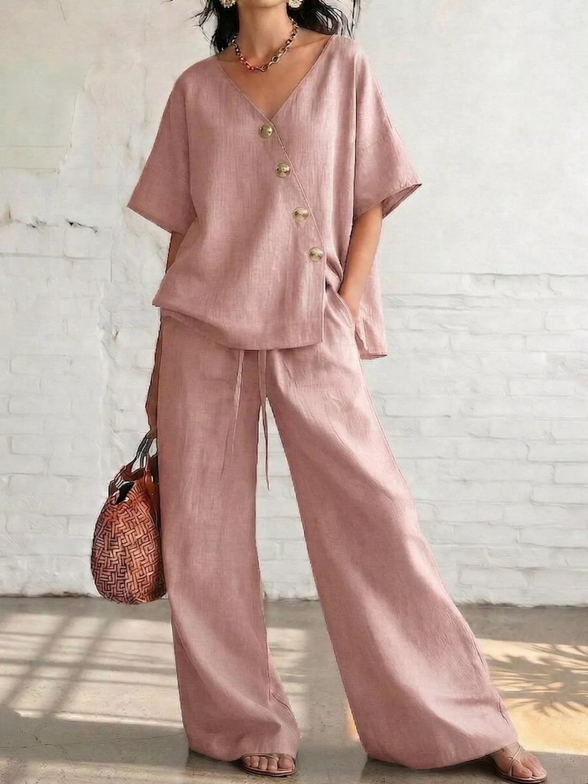 Plus size full surplice half sleeve top and wide-leg pants matching set by Trendsi, featuring a stylish, comfortable ensemble.