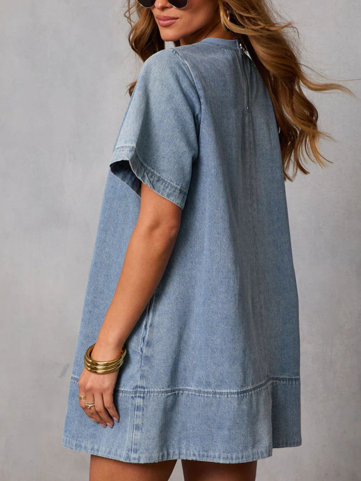 Women’s casual denim dress with short sleeves and pockets by Plush Fashion Hub, shown on a model.