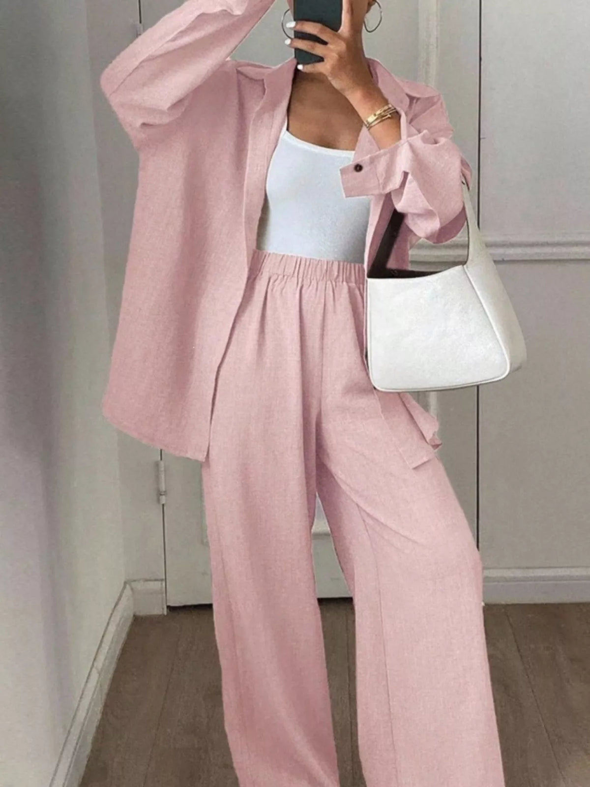 Trendsi long sleeve button-up shirt and wide leg pants set displayed on a hanger, featuring a stylish, coordinated fashion look.