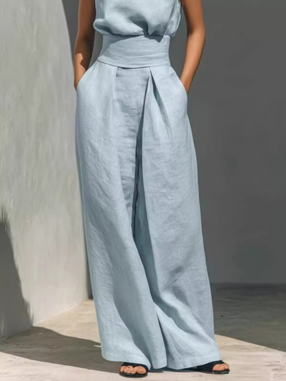 Plus size full length sleeveless jumpsuit with wide-leg design and smocked waist, by Trendsi, shown in the image.