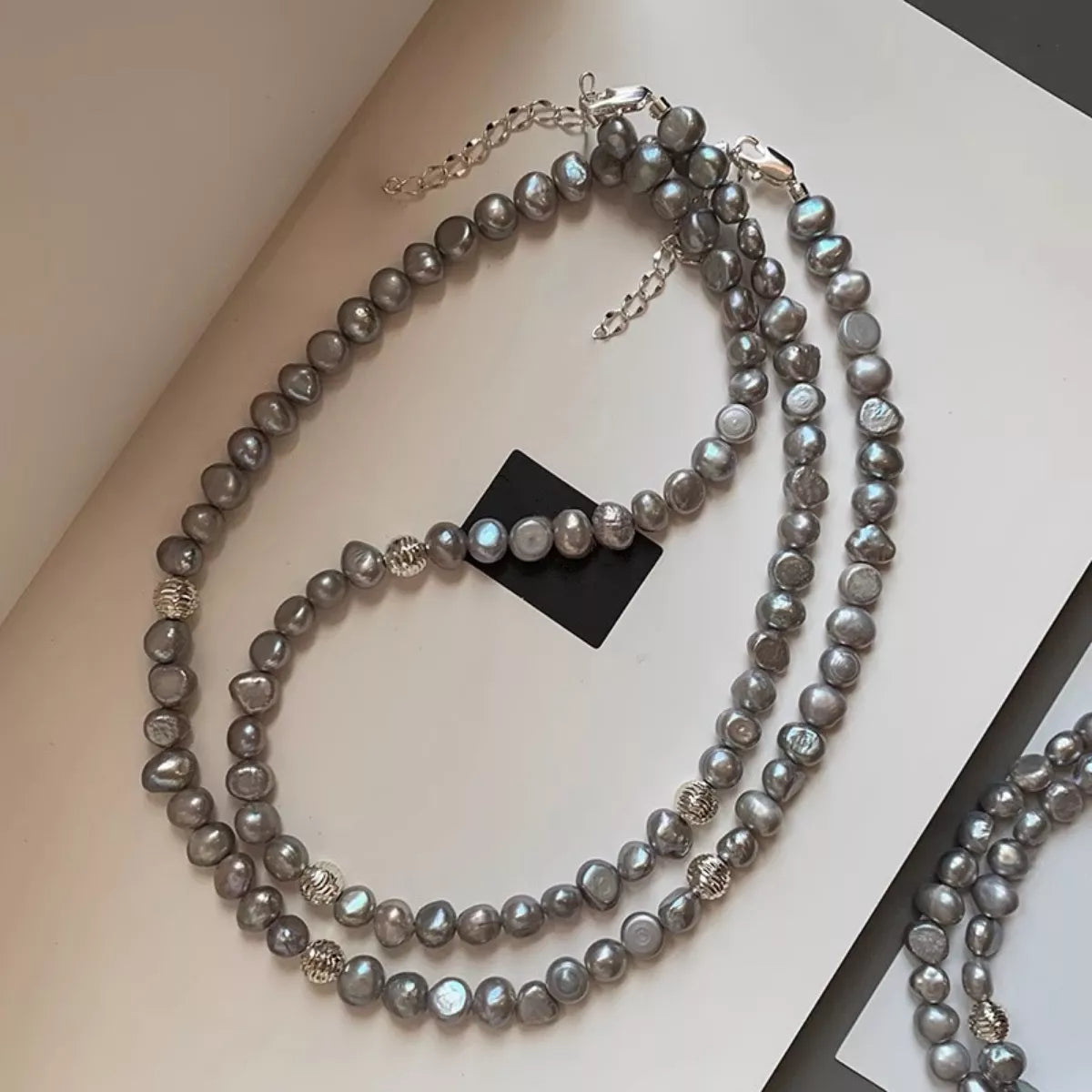 Elegant pearl choker necklace with glossy white pearls and a silver clasp, designed by Plush Fashion Hub.