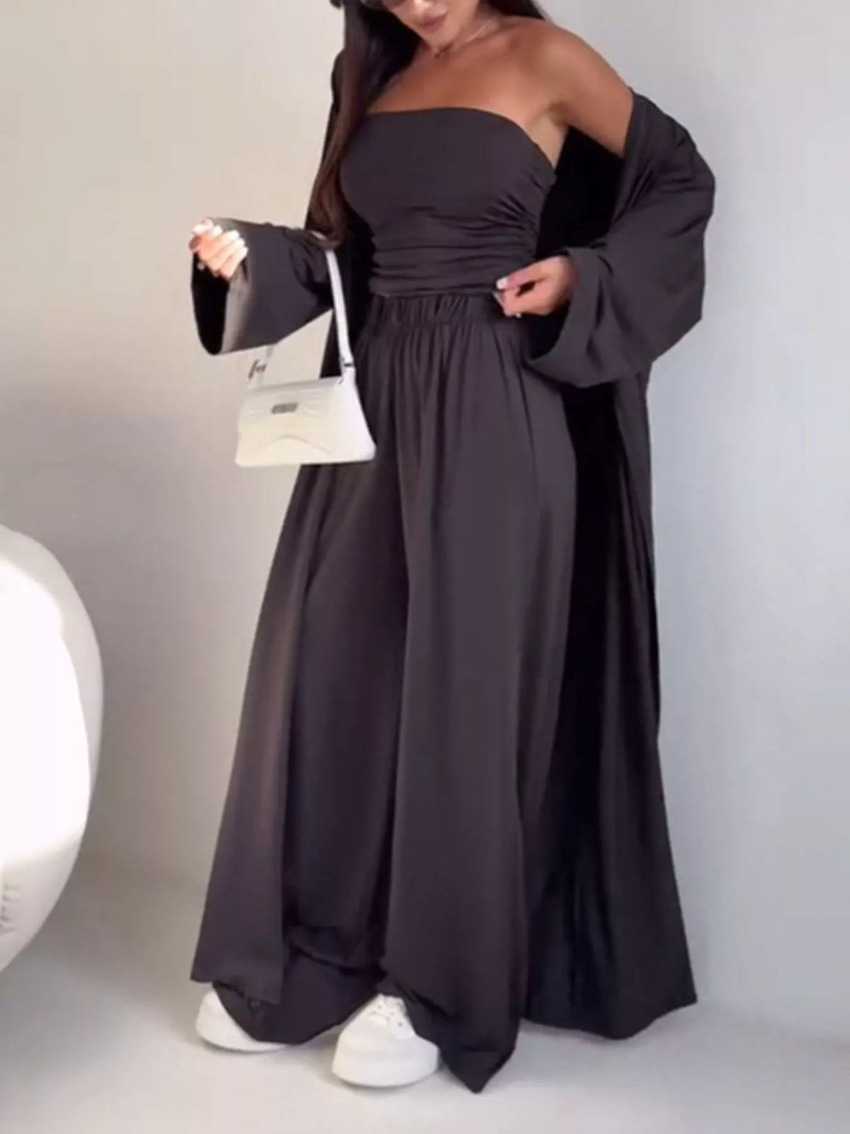 Trendsi chic 3-piece set with strapless ruched crop top, wide-leg pants, and matching cardigan, displayed on a model.
