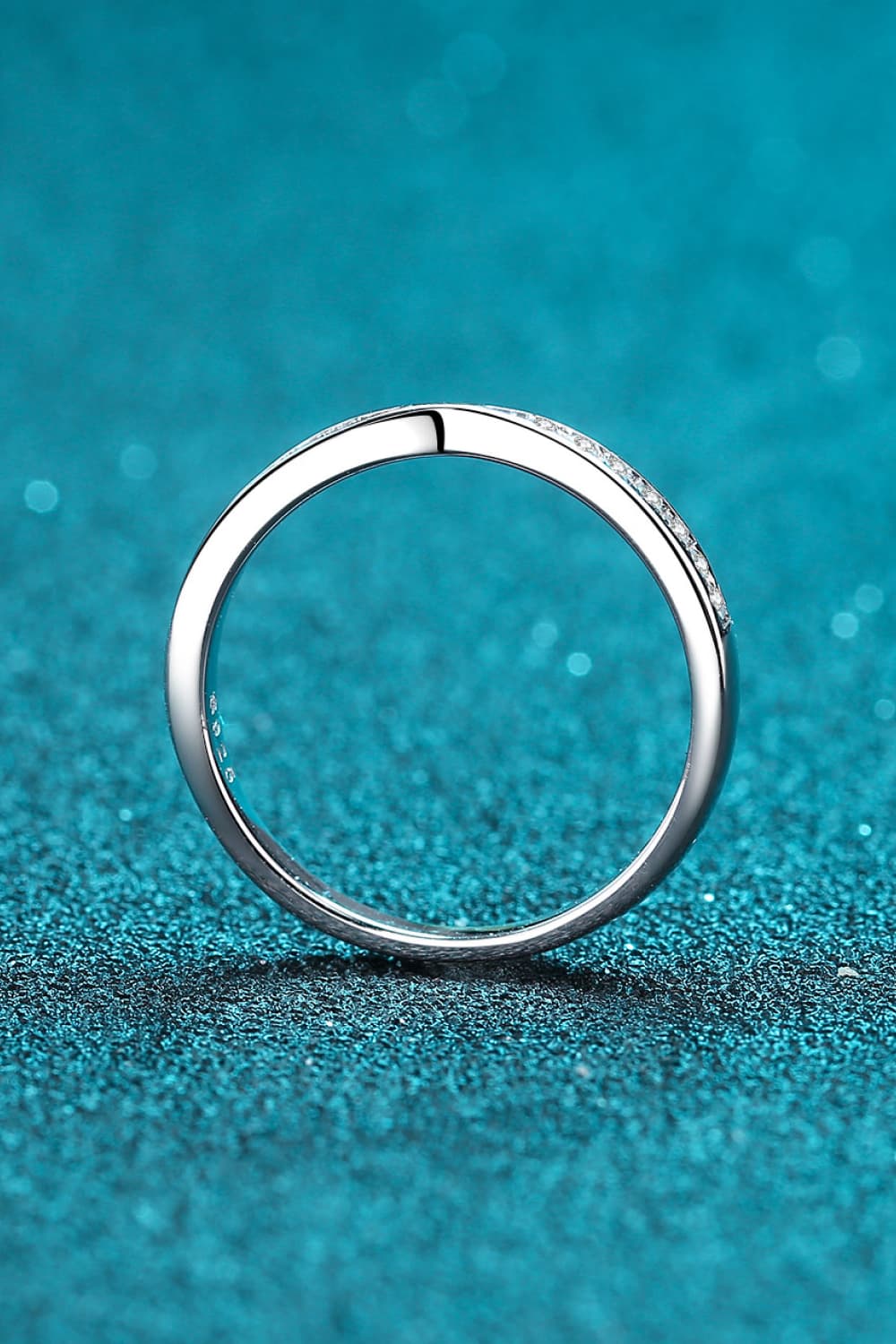 Rhodium-plated moissanite ring with a sparkling center stone, elegant jewelry piece from Plush Fashion Hub.
