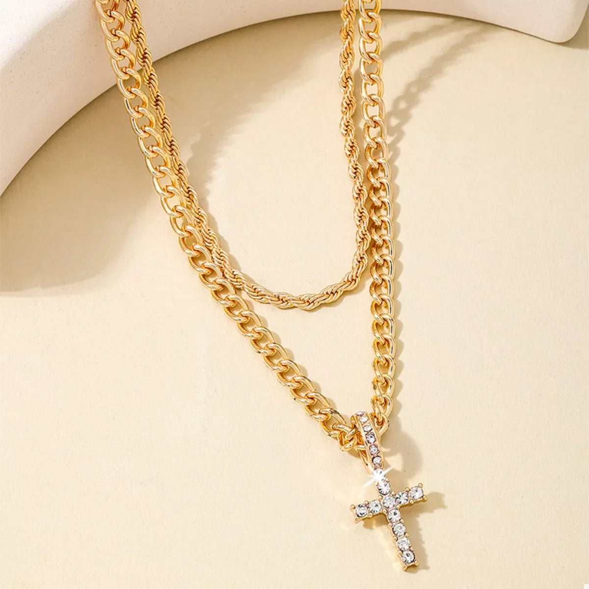Gold layered chain necklace with cross pendant, featuring a stylish multi-layered design, by Plush Fashion Hub.