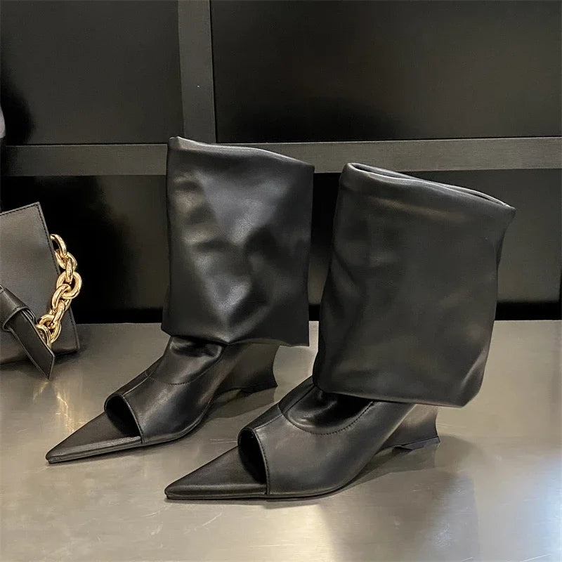Elegant black leather, peep-toe knee-high boots with a slouchy shaft and a sculpted wedge heel.