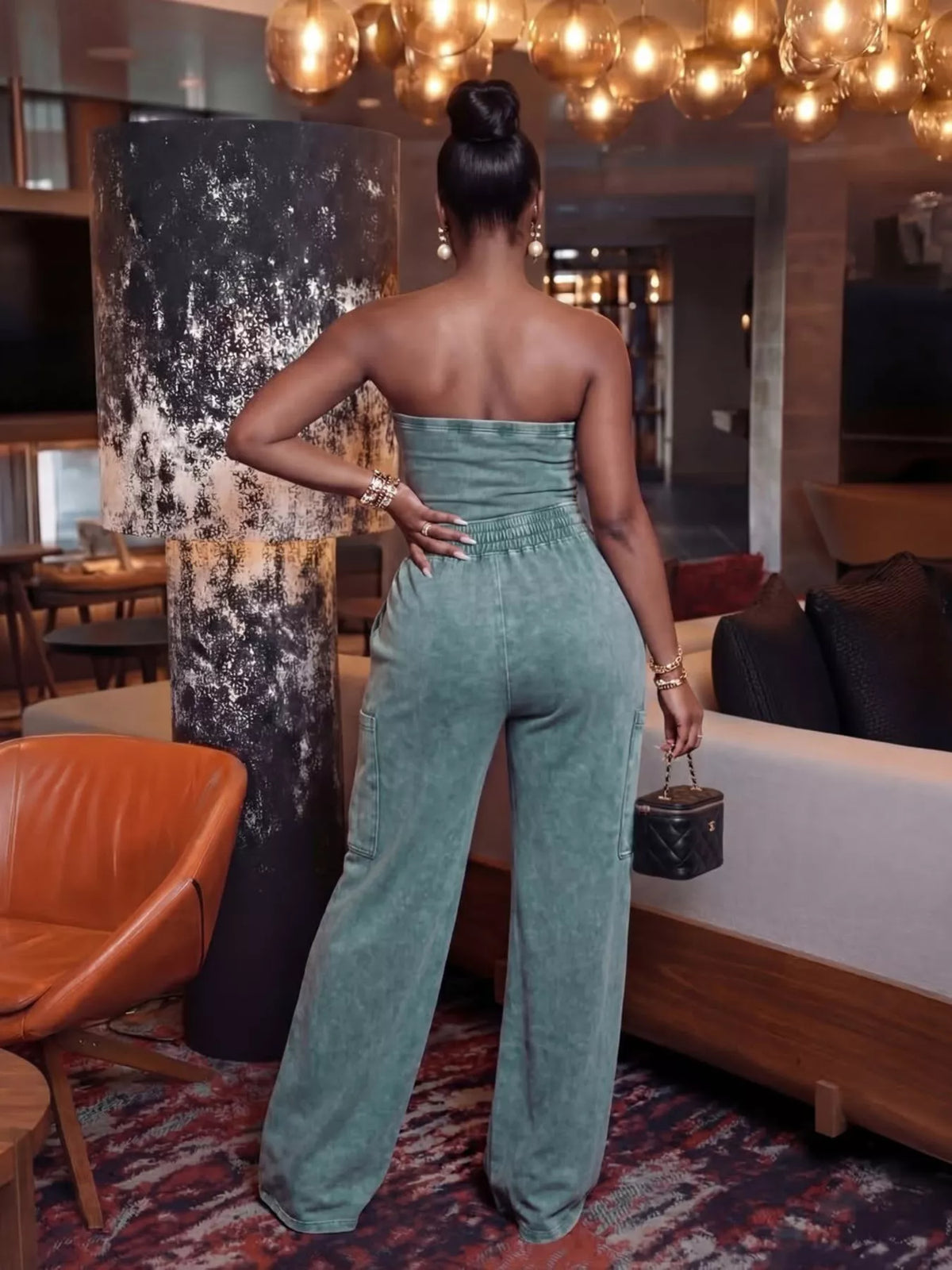 Drawstring strapless wide-leg jumpsuit from Trendsi featuring a fitted bodice and flowing pant legs in a stylish, modern design.