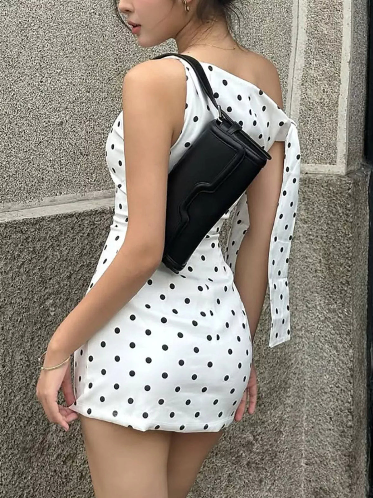 Polka dot sleeveless mini dress with bow accents by Plush Fashion Hub, featuring a playful pattern and stylish design.
