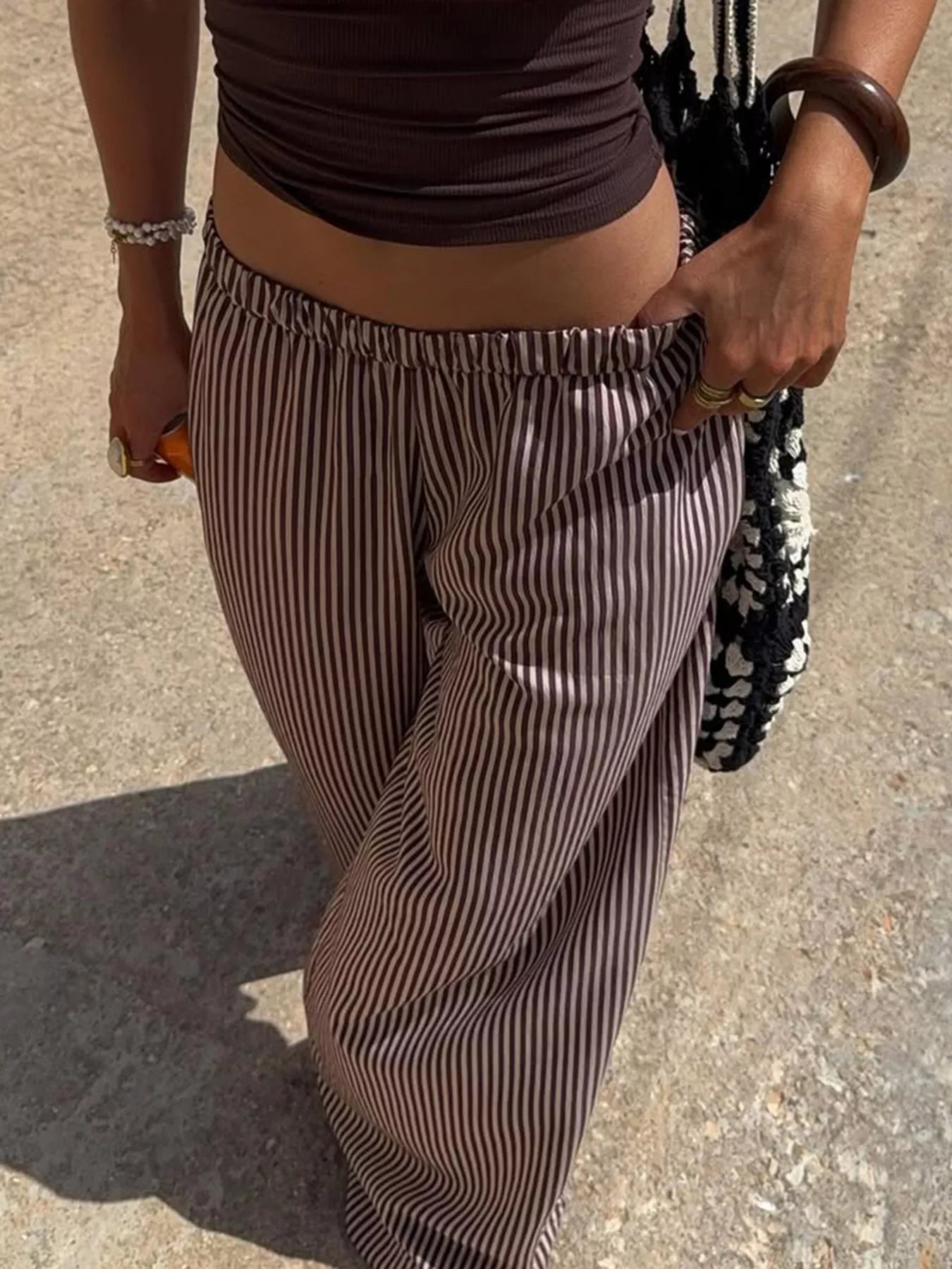 Striped wide-leg pants from Trendsi featuring a tied waist and relaxed fit, perfect for casual or stylish outfits.